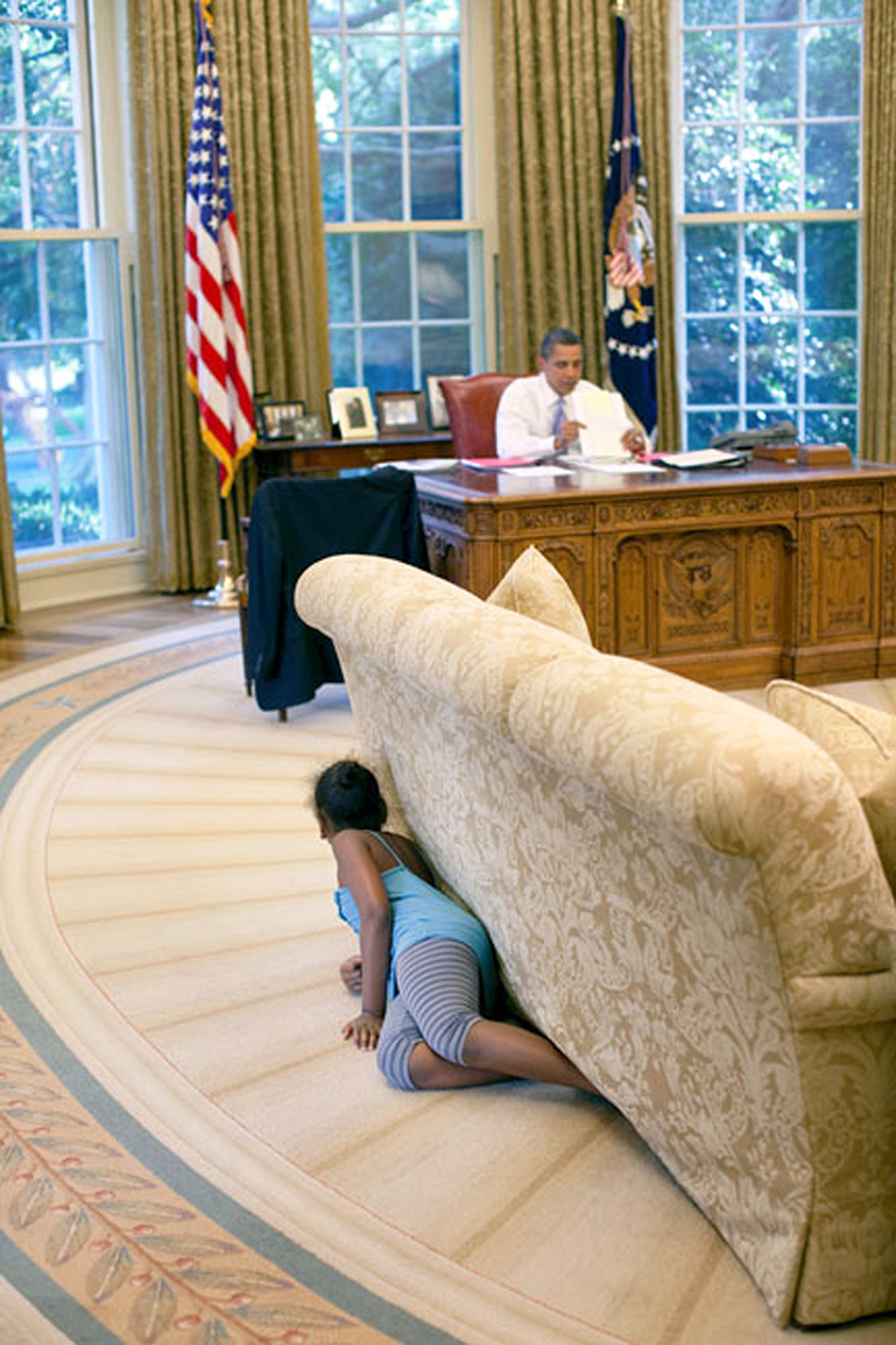 President Barack Obama's Daughter Sasha Hides Behind The Sofa As She Sneaks Up On Him At The End Of The Day In The Oval Office