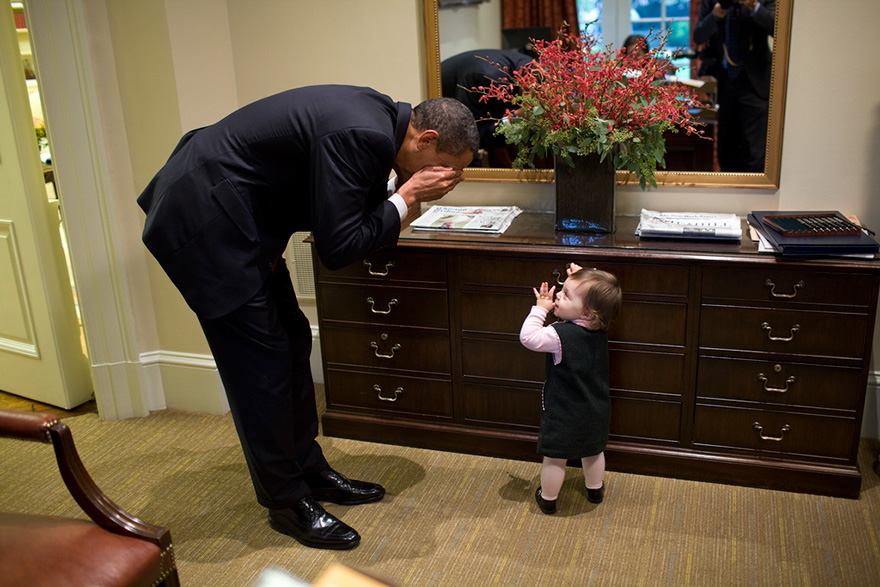 The President Plays Peek-A-Boo With The Daughter Of White House Staffer Emmett Beliveau In The Outer Oval Office