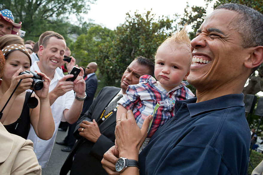 President Barack Obama Holds A Baby While Greeting Guests During An Independence Day Celebration