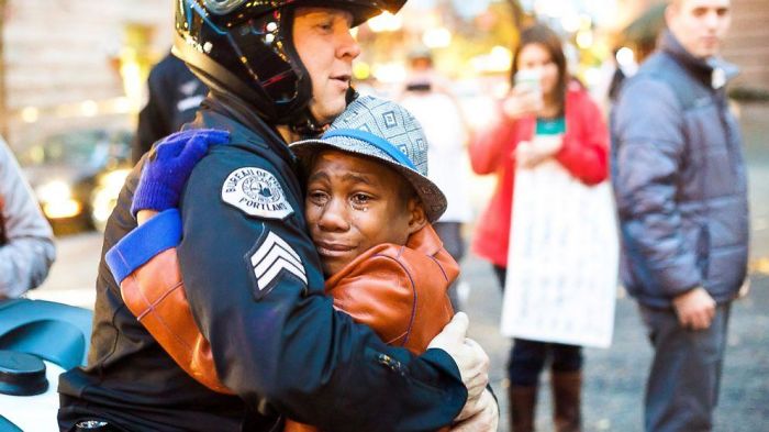 Officer And Crying Boy Hugging
