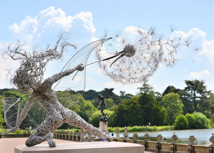 Wire sculpture of a woman blowing a dandelion in a scenic outdoor park among amazing sculptures in the world