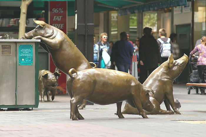 Bronze pig sculptures in a public space, showcasing unique and captivating art among amazing sculptures in the world.