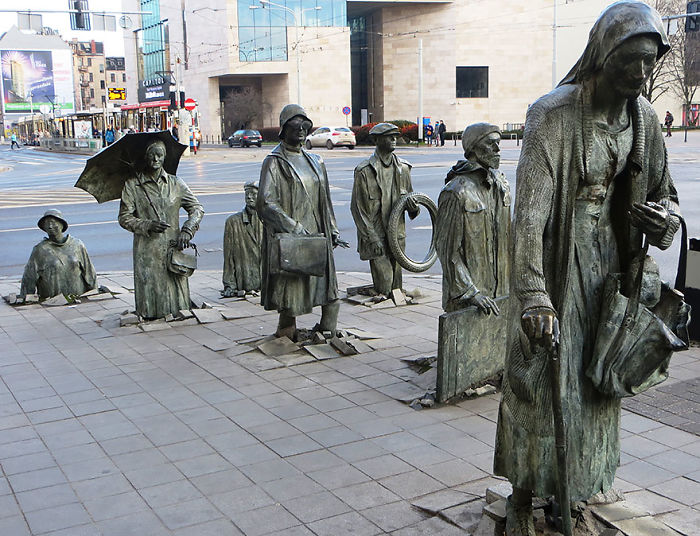 Bronze sculptures of people emerging from the pavement, showcasing one of the most amazing sculptures in the world.