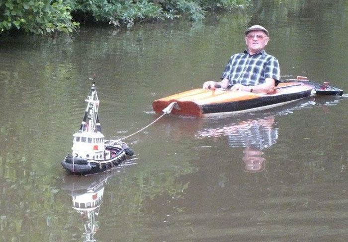 Man Spotted Using Tiny Tug Boat To Effortlessly Cruise Down The River