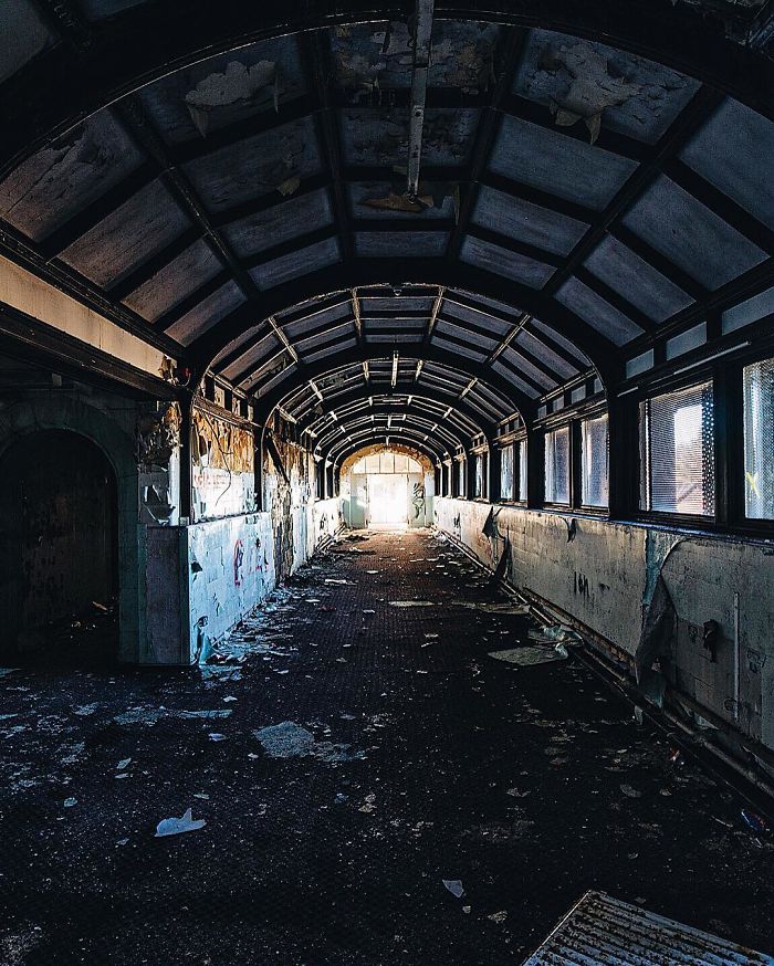 Abandoned Britain corridor with peeling walls and debris, showcasing the eerie atmosphere of UK abandoned places.