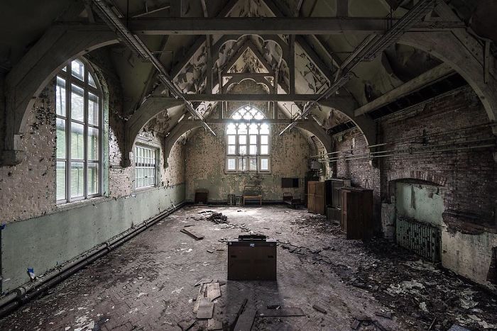 Abandoned Britain interior of a decaying old building with peeling walls and broken windows in a deserted UK location.
