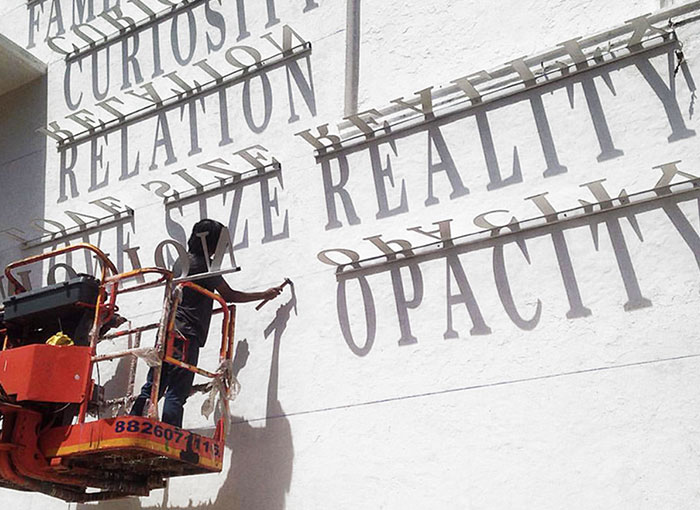 Typographic Shadow Graffiti Turns Boring Building Into Ever Changing Masterpiece