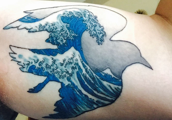 Colorful hand bird and waves tattoo 