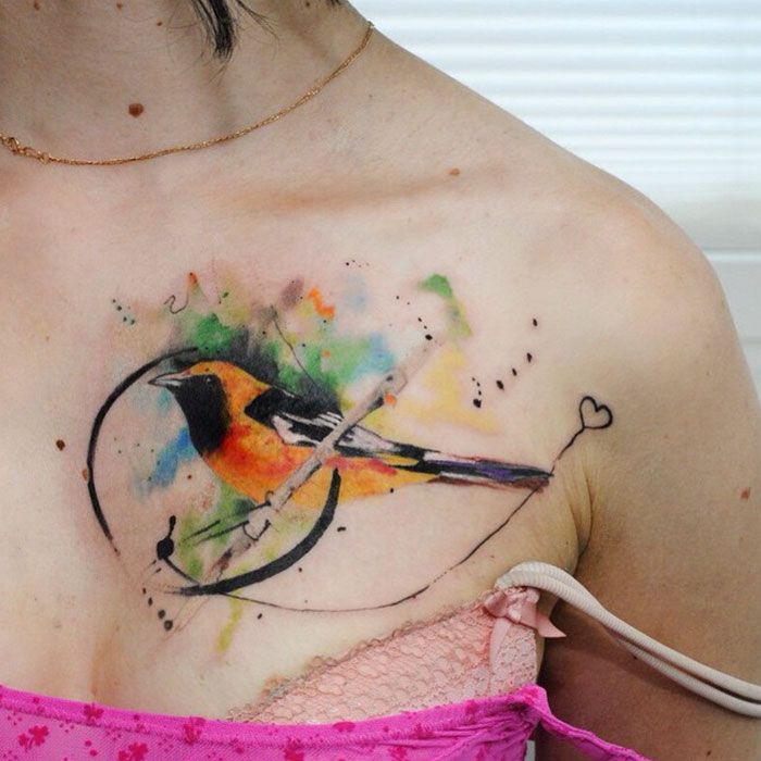 Colorful collarbone bird tattoo 