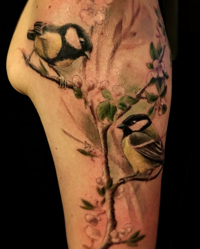Colorful arm bird and flowers tattoo 