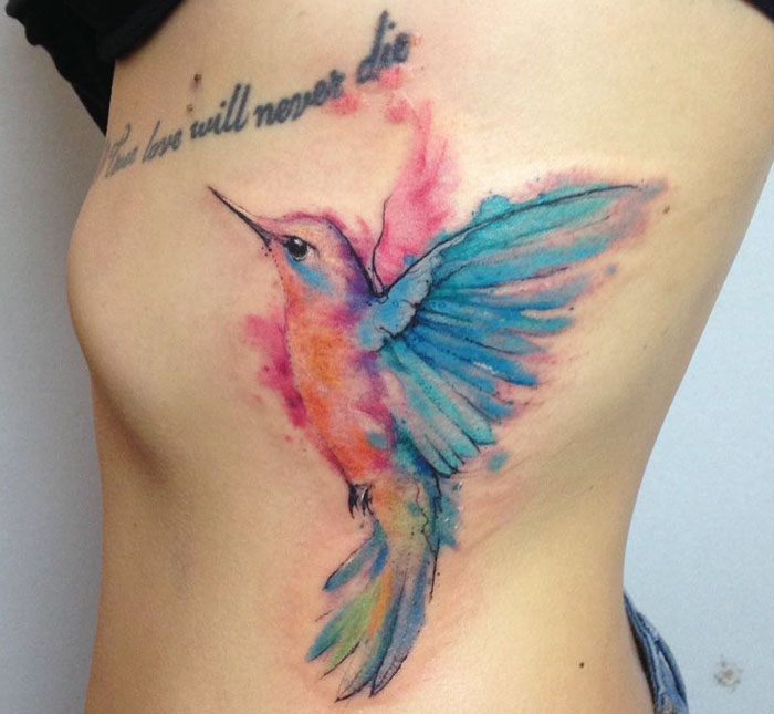 Colorful cheekbone bird tattoo 