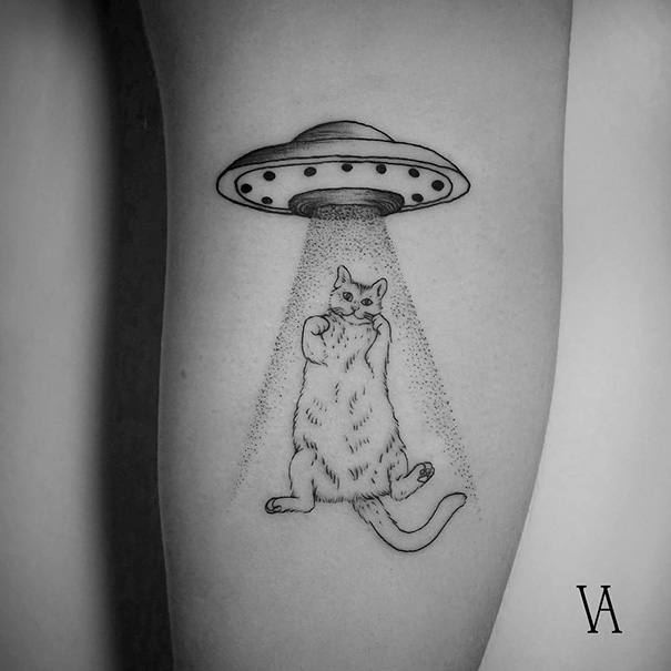 Cat and spaceship arm tattoo