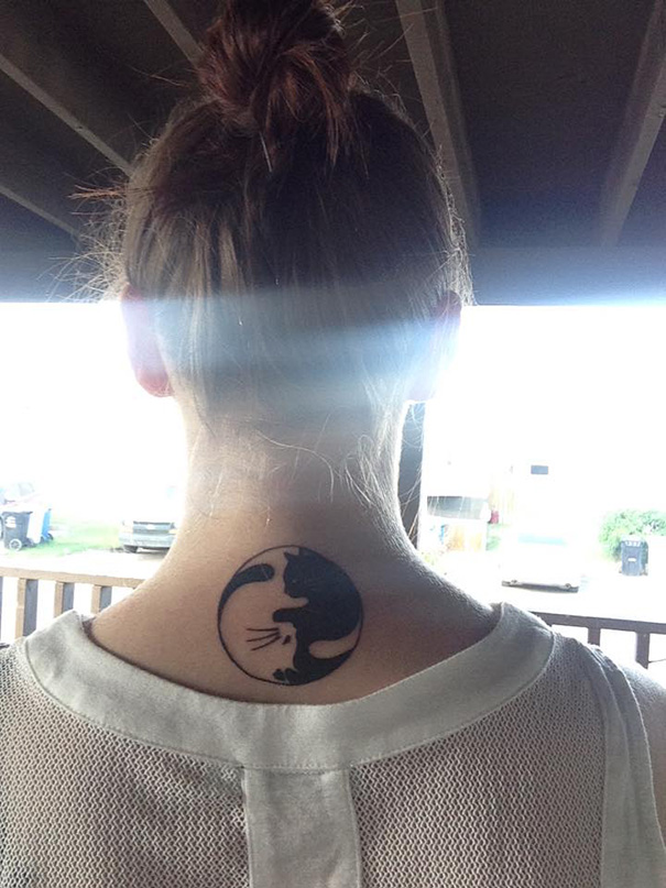 Minimalist cat face tattoo on the back of the neck
