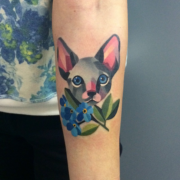 Colorful cat face with blue flowers arm tattoo