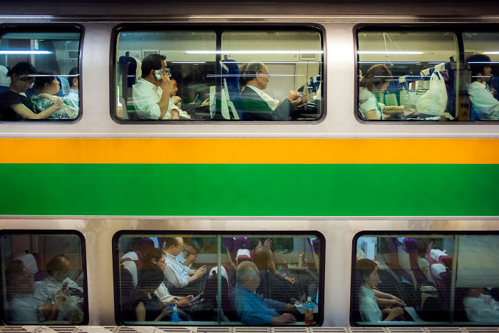 Passengers inside a Japan train captured in street photography highlighting the rarely seen side of urban life.
