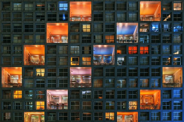 Night view of a modern residential building in Japan with illuminated windows, showcasing urban street photography.