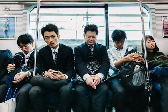 Commuters sitting quietly inside a Japan train captured in a rare Japan street photography shot.