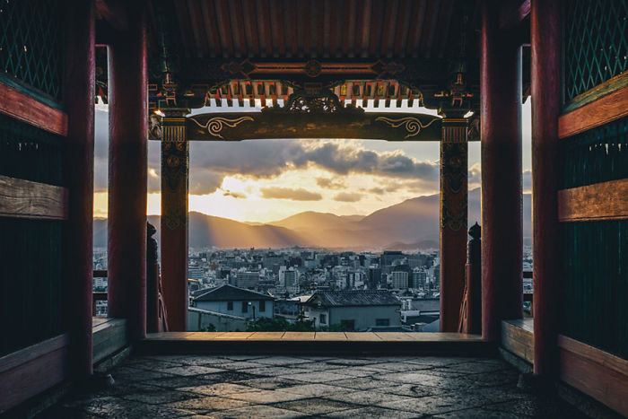 View of a Japanese city framed by traditional architecture at sunset, showcasing Japan street photography.