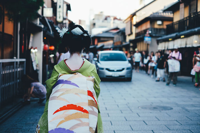 Woman in traditional kimono walking on a busy street in Japan, showcasing authentic Japan street photography scenes.