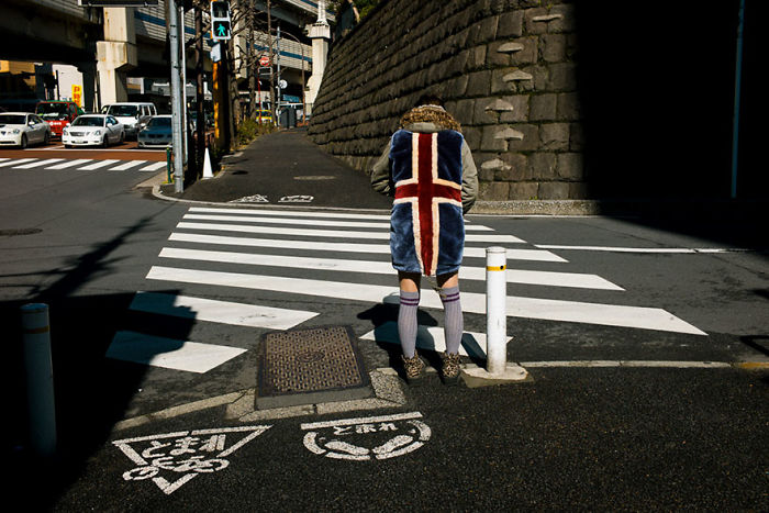 Person wearing a colorful coat standing on a pedestrian crossing in Japan street photography capturing daily urban life.