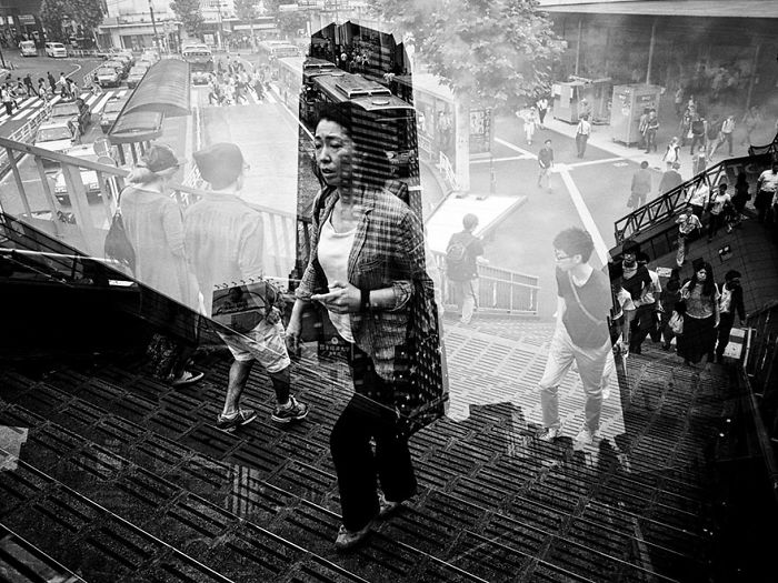 Black and white Japan street photography showing pedestrians on stairs and reflections capturing everyday urban life.