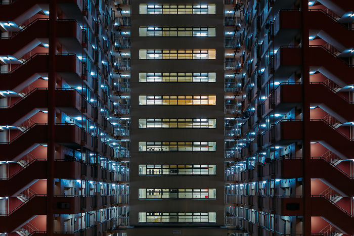 Night view of Japan street photography showing illuminated apartment building corridors in urban setting.