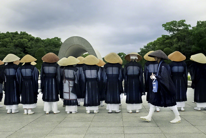 Group of people in traditional hats and robes gathered at outdoor site, showcasing Japan street photography culture and attire.