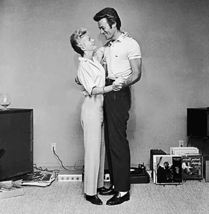 Clint Eastwood And His First Wife, Maggie, Dancing Next To A Turntable And A Rack Full Of Records In A Living Room In The 60's