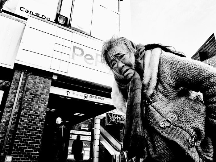 Black and white Japan street photography of an elderly person in a city setting, capturing the rarely seen side of urban life.