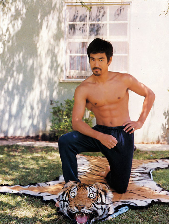 Young Bruce Lee Posing On A Tiger Carpet