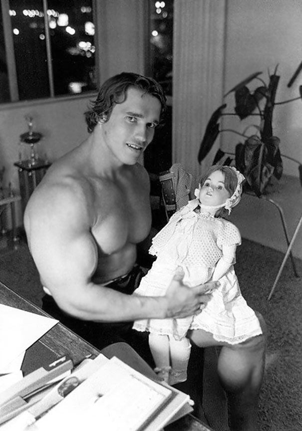 Young Arnold Schwarzenegger Holding A Doll In The 70's