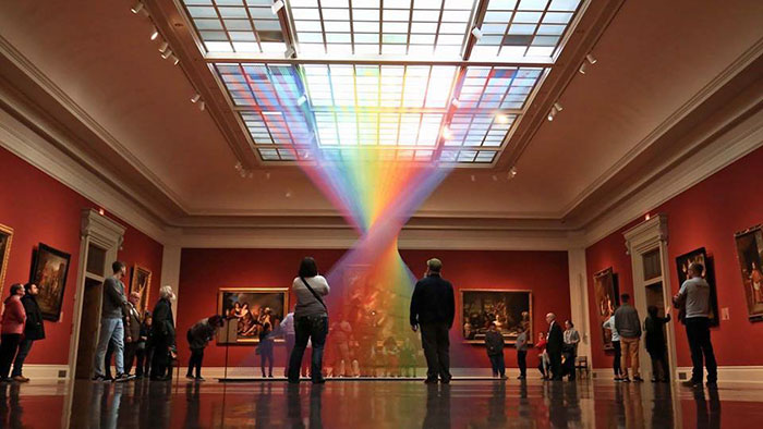Este arco iris artificial atrapado en una galería de arte está hecho con miles de hilos de colores