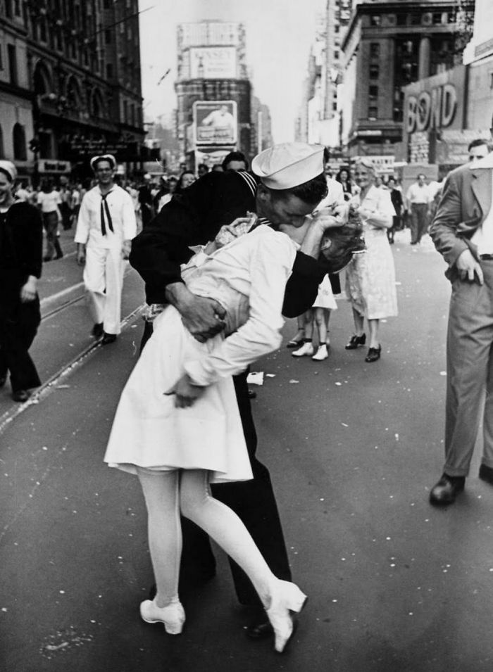 A sailor kisses a nurse in a famous historical photo on a crowded street.