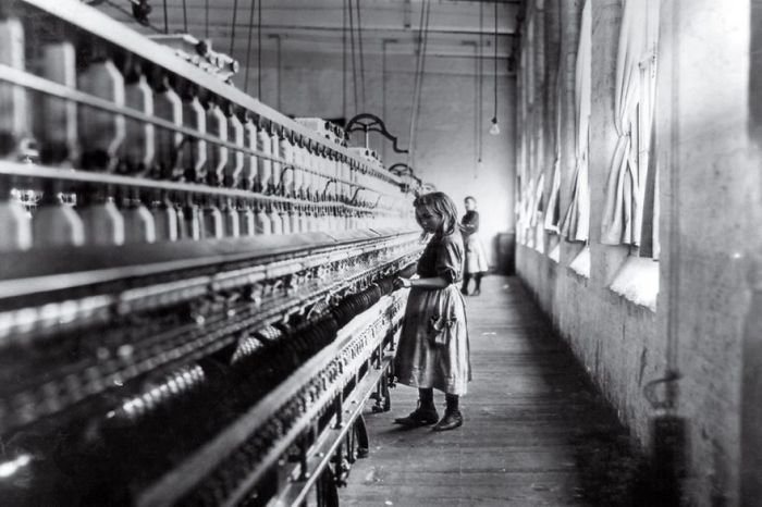 Young girl working in a textile factory, one of history's famous photos, highlighting labor conditions.