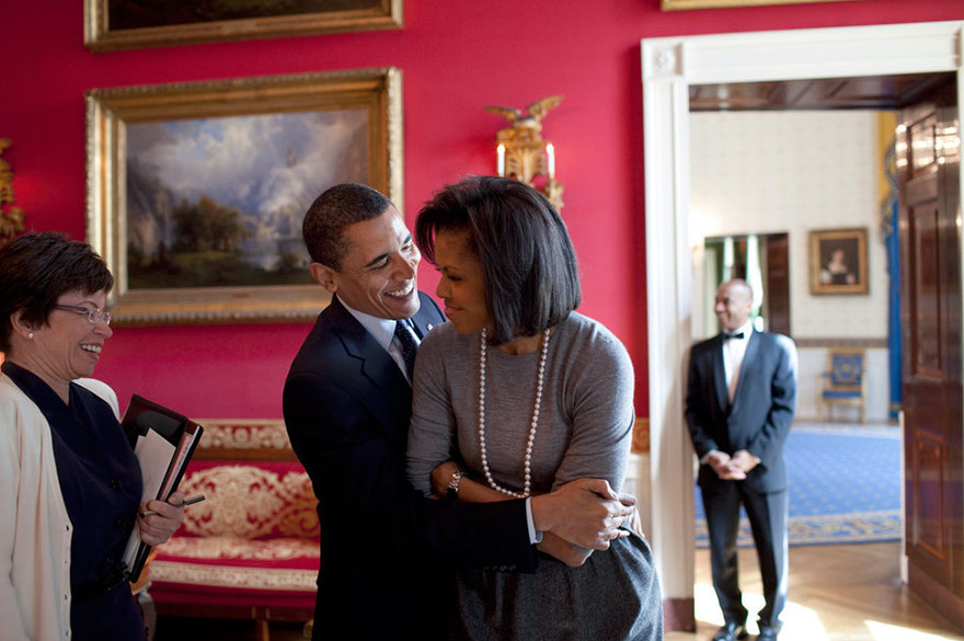 President Barack Obama Hugs First Lady Michelle Obama In The Red Room While Senior Advisor Valerie Jarrett Smiles At The White House On March 20, 2009
