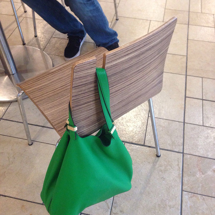 green bag hanging on the chair