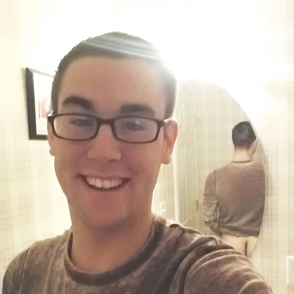 Man taking a selfie with the butt in the mirror reflection 