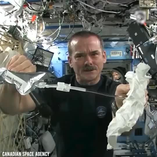 Astronaut Wrings A Wet Towel In Space