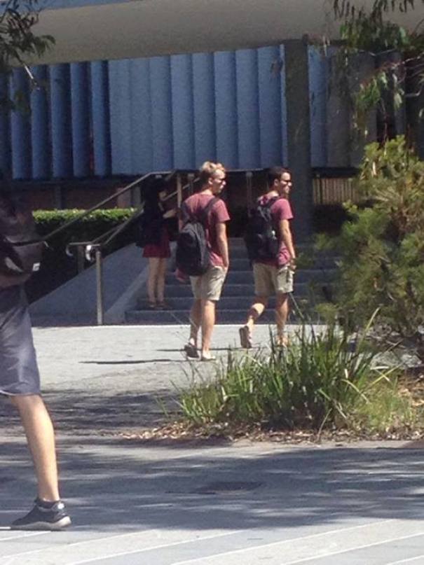 Two mans walking and wearing same clothes with backpacks