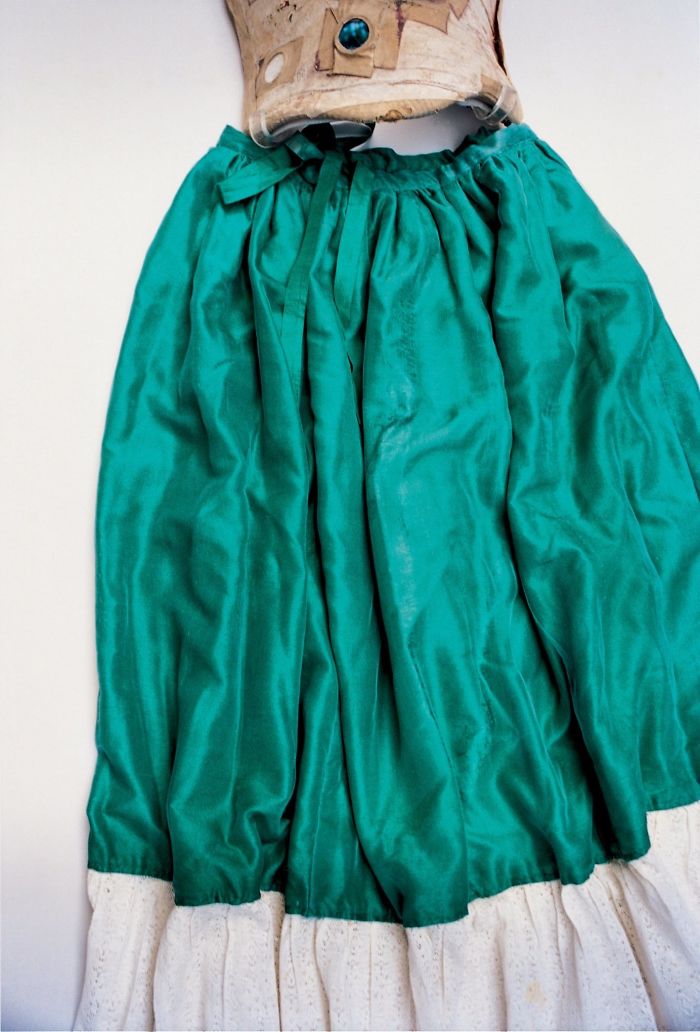 Falda de seda verde y encaje unida a uno de sus corsés
