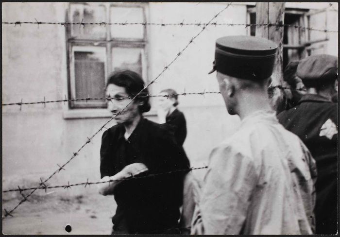 1942: Policía con una mujer tras la alambrada del gueto