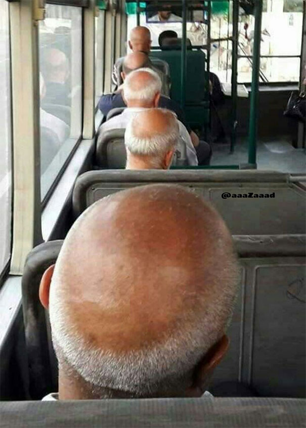 Mans sitting in one line in the bus and looks alike