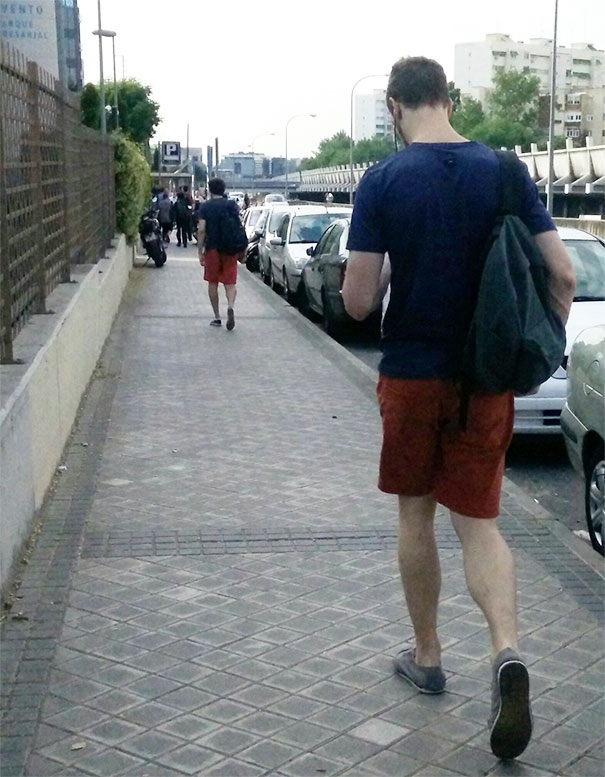 Two man walking and wearing blue shirts with red shorts