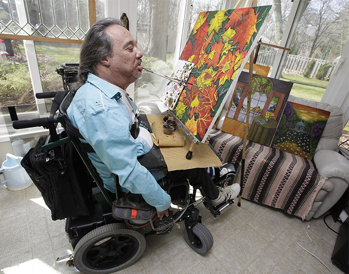 Jeffrey Ladow Uses His Mouth To Hold A Paint Brush While He Works On An Oil Painting In His Home