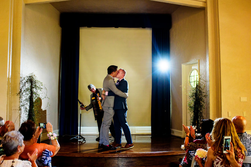 Two men kissing and hugging on stage 