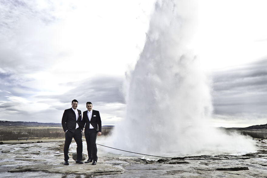 Two men posing near a geyser