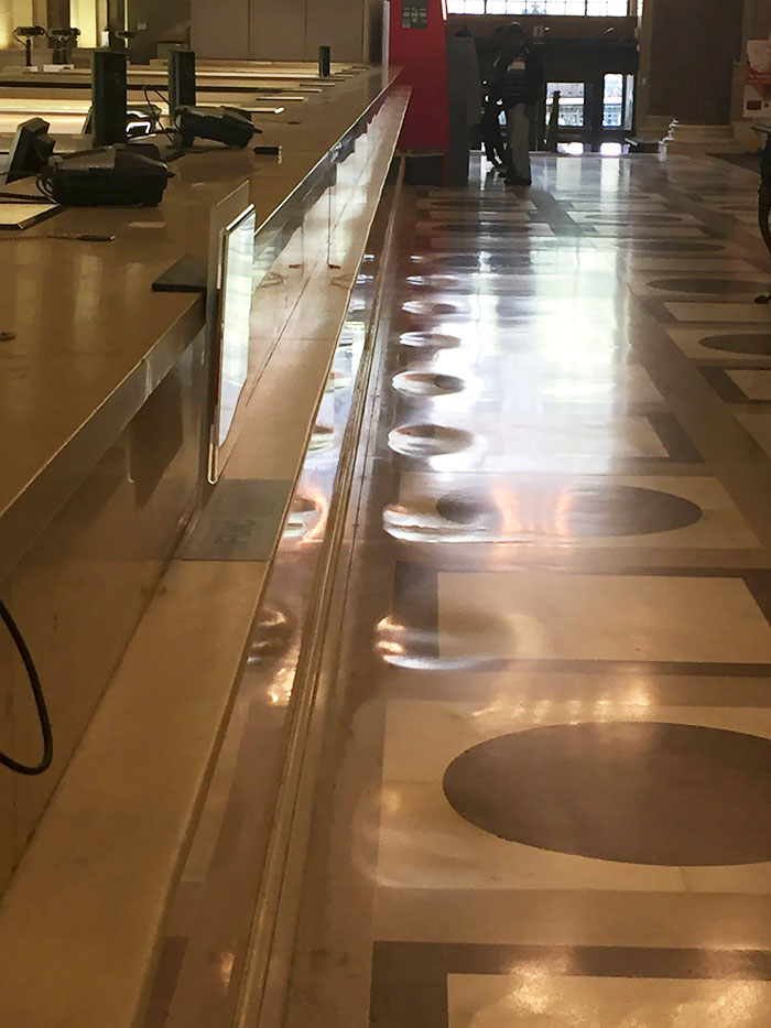 El suelo de mármol de este banco está desgastado por los pies de los clientes ante el mostrador