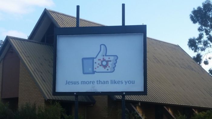 Sign with emoji thumbs up with Christian stigma in it and written below ‘Jesus more than likes you‘