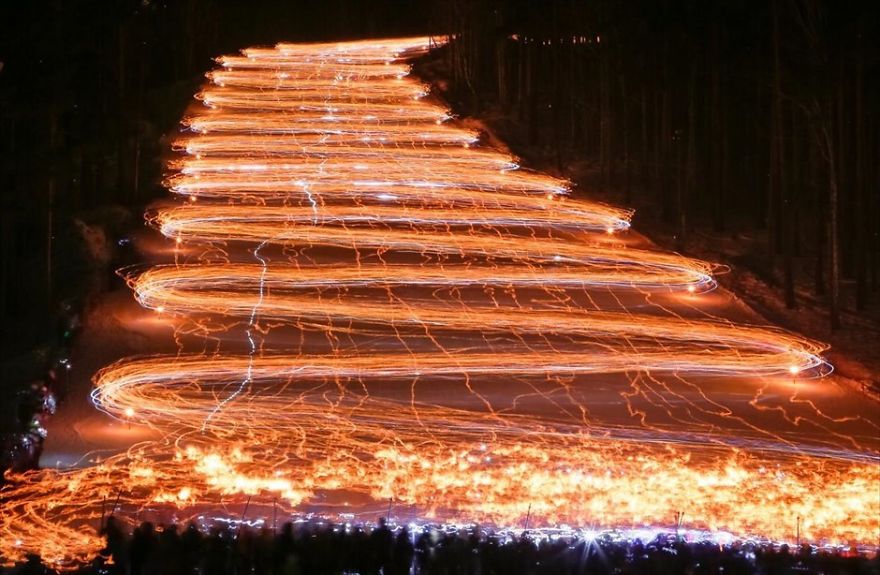 Long Exposure Of Hundreds Of Skiers Holding Flashlights