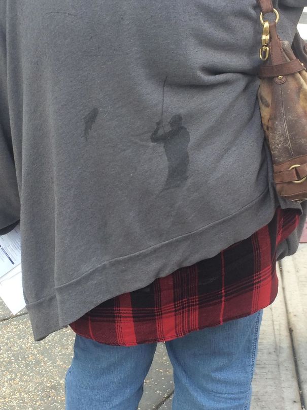 The Stain On This Woman's Jacket Looks Like A Fisherman Who's Reeling In A Fish